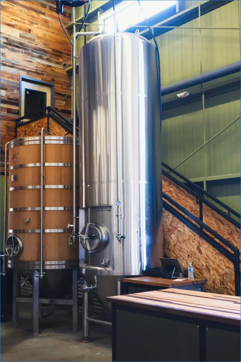 Large stainless steel and wooden brewing tanks.
