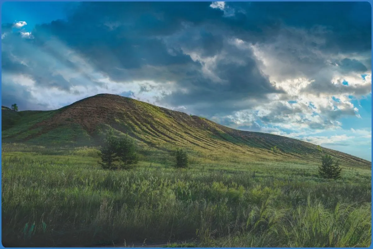 Grassy hill under a cloudy sky