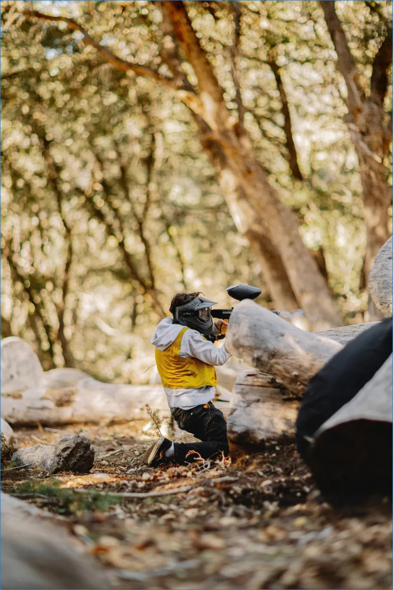 Person playing paintball in a forest