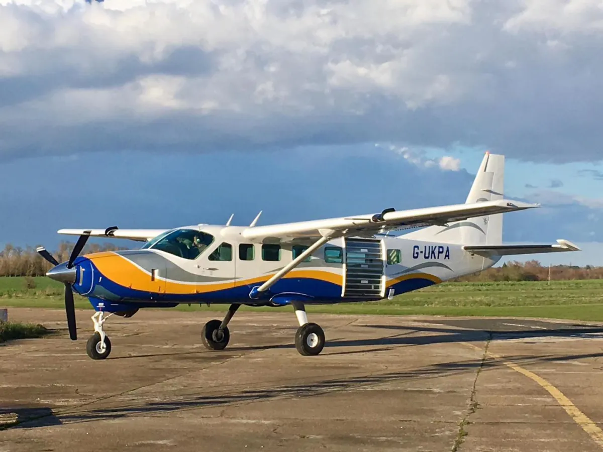 Open-door skydiving plane in flight over Suffolk countryside