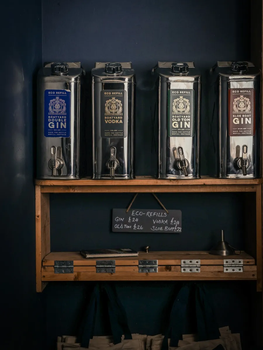 Four eco-refill liquor dispensers on a shelf.