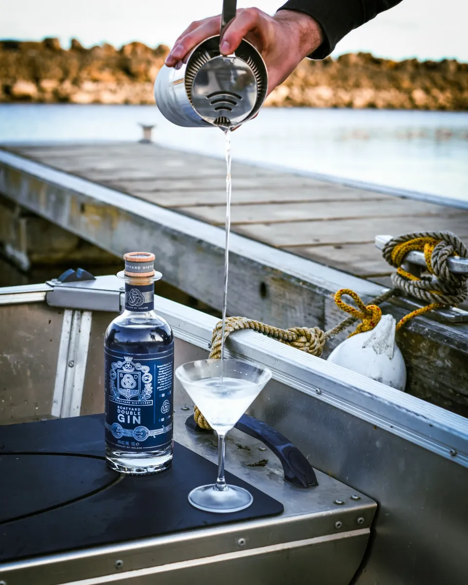 Pouring gin into a martini glass on a boat